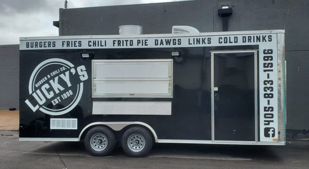 Lucky's Burger and Chili Co. food trailer with service window and full wrap graphics listing menu items